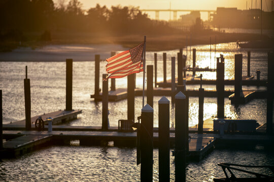 A tattered American flag blows in the wind attached to boat dock