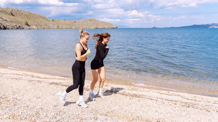 Women engage in cardio training along a serene beach under a sunny sky