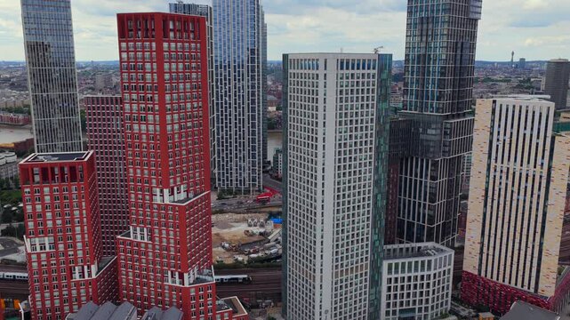 Aerial video showcasing the Modern High-Rises of Nine Elms and Vauxhall with a train traveling down. London UK 