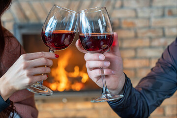 Cheers with Red Wine by a Fireplace