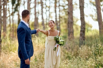Bride and Groom Holding Hands in a Serene Forest Setting