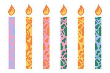 Colorful spotted birthday candles with burning flame isolated on white background
