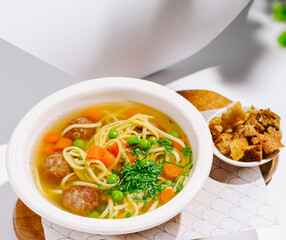Delicious bowl of meatball soup with pasta and vegetables served warm