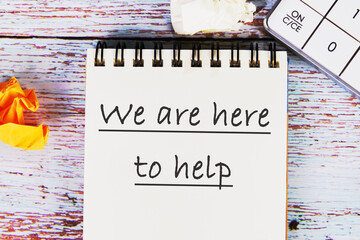 We are here to help, Text It is written on the notebook in close-up