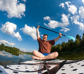 Man Taking Selfie on Paddleboard in Scenic Lake