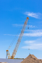 Construction site with construction crawler cranes and multi storey unfinished buildings, Many high rise cranes and industrial construction equipment, Contruction site blue sky background.