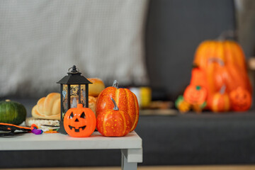 Halloween Decor. Festive pumpkins and lanterns on a table, creating a cozy autumn atmosphere.