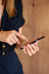 Close-up of woman using modern smartphone at home Female hands tapping touchscreen while holding...