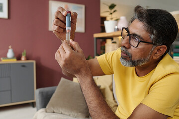 Man preparing insulin injection for diabetes management at home