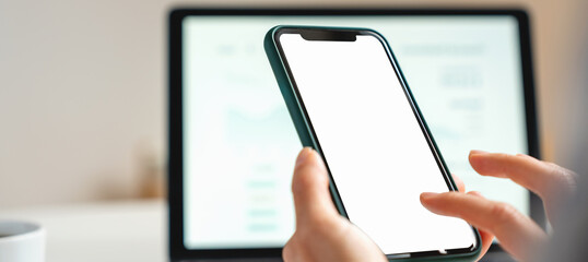 Mockup closeup empty screen of smartphone in hands against computer monitor
