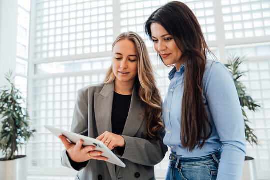 Business professionals collaborating on tablet in modern office - Powered by Adobe