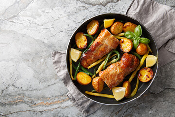 Tender pork tenderloin garlic lemon baked with potatoes and green beans close-up in a frying pan on...