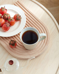 Cozy Autumn Morning Coffee, Persimmons, and Wooden Tray, Cup of coffee and fresh persimmons on a...