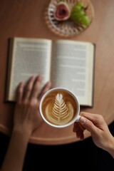Relaxing Morning with Latte, Book, and Fruit, A cup of latte art coffee with book on wooden table.