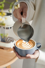 Expert Barista Pouring Milk into Latte Art Coffee, Woman pouring milk into cup of latte art coffee,...
