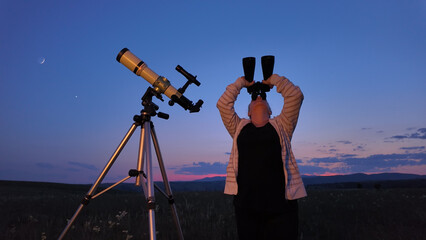 Amateur astronomer using telescope and binoculars  for watching stars, Moon, planets and other...