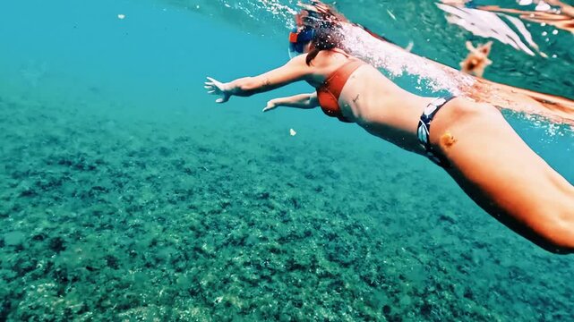 Woman snorkeling in crystal clear water exploring seabed