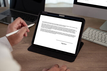 Digital signature concept with a person using a stylus to sign an electronic document on a tablet,...