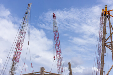 Crawler crane on blue sky white clouds background, Real estate industry. Red crawler crane use reel lift up equipment in construction site. Crane for rent. Crane dealership for construction business.