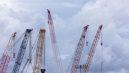 Crawler crane on blue sky white clouds background, Real estate industry. Red crawler crane use reel lift up equipment in construction site. Crane for rent. Crane dealership for construction business.