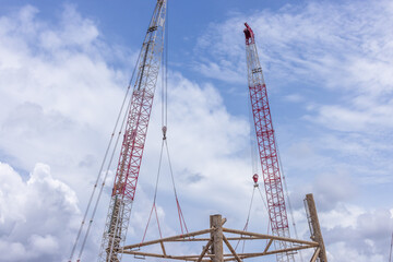 Crawler crane on blue sky white clouds background, Real estate industry. Red crawler crane use reel lift up equipment in construction site. Crane for rent. Crane dealership for construction business.