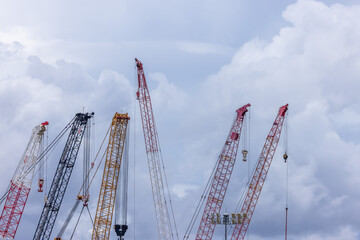 Crawler crane on blue sky white clouds background, Real estate industry. Red crawler crane use reel lift up equipment in construction site. Crane for rent. Crane dealership for construction business.
