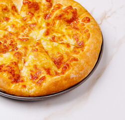 Delicious cheesy pizza served on a black plate with a marble background