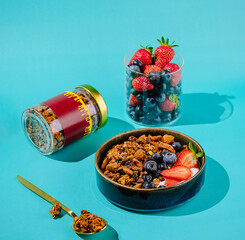 Colorful breakfast with granola and fresh fruit on a bright backdrop