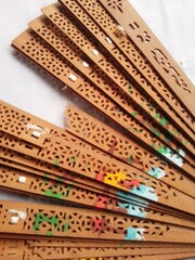 Decorative Wooden Hand Fan with Intricate Floral Design on White Background