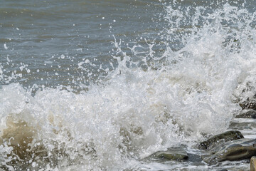 Sea water splashing over the stones on the beach