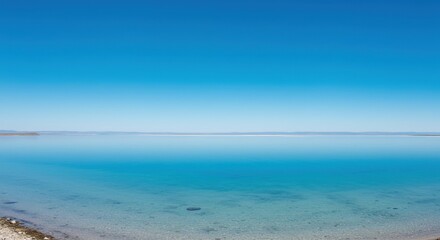 Obraz premium Calm Lake Water Reflecting Clear Blue Sky on a Sunny Day