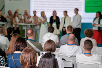 Group of people seated at a conference attending a panel discussion with presenters