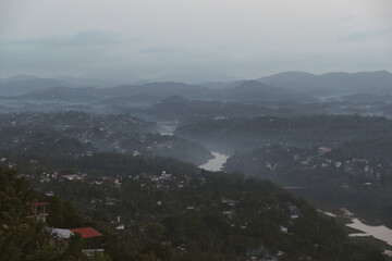 Aerial view of Kandy, the second largest city of Sri Lanka, with fog covering the valley and surrounding hills at dawn