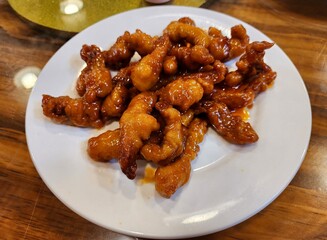 fried pork with garlic and sweet sauce in white plate dish