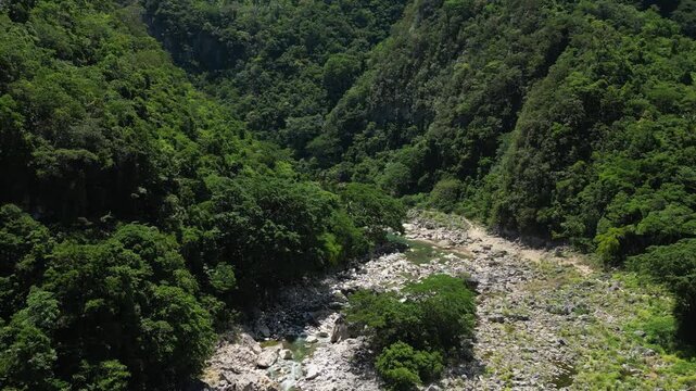 A distant aerial shot captures vast expanses of lush green forests around Tinipak River, Tanay Rizal, with the river barely visible, emphasizing the sprawling natural wilderness from above.