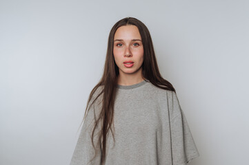 portrait of young woman shows a serious expression with striking eyes on light background