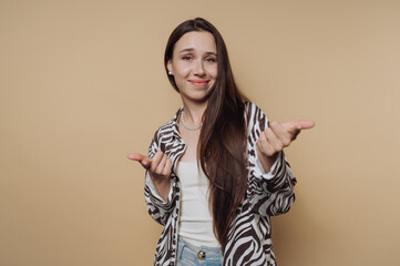 portrait of young confident woman creates a playful gesture on calm yellow background