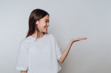 portrait of young woman shows an open hand gesture, highlighting a sense of welcome and openness on...