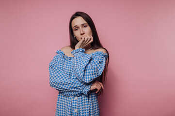portrait of young thoughtful woman reflects on life‚Äôs dilemmas while in a checkered top on...