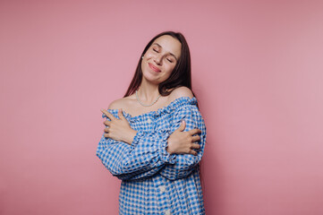 portrait of young woman wearing a blue checkered dress smiles, showcasing a sense of happiness on...