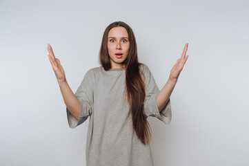 portrait of young worried woman displays disbelief through her hand gestures on light background