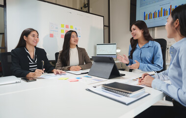 Businesswomen having productive meeting discussing strategy in office boardroom