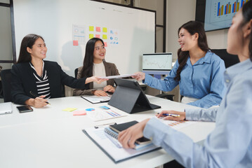 Businesswomen exchanging documents during office meeting