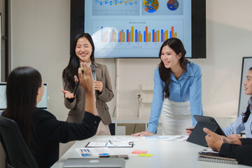 Businesswomen leading meeting with charts and data analysis displayed on screen