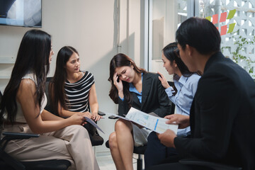 Business team comforting stressed colleague during meeting