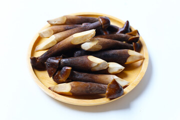 Termite mushrooms with long stems, white tips, and dark brown caps.