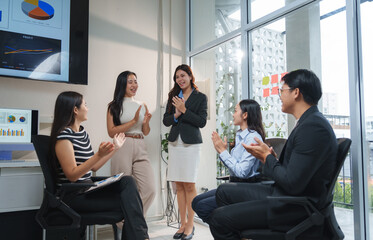 Business team clapping, celebrating success in modern office