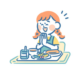 A girl clasping her hands in front of her school lunch