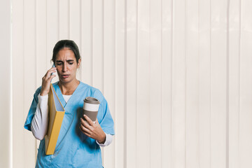 Physiotherapist holding coffee and folder while calling patient