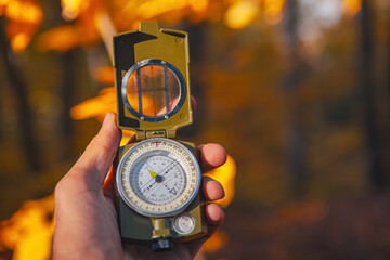 compass in the hand of a tourist man. autumn and autumn landscape.